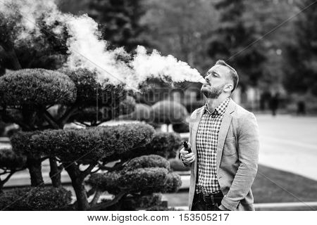 Men With Beard Smoking Electronic Cigarette Outdoor