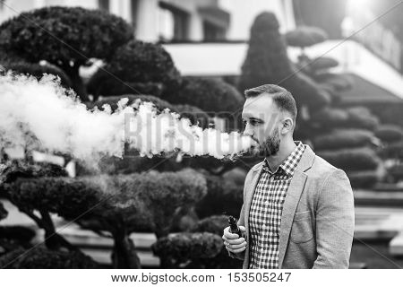 Men With Beard Smoking Electronic Cigarette Outdoor