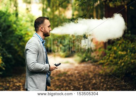 Men With Beard Smoking Electronic Cigarette Outdoor