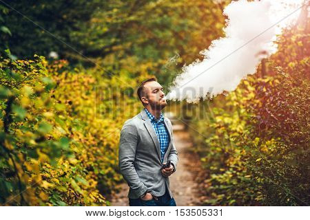 Men With Beard Smoking Electronic Cigarette Outdoor