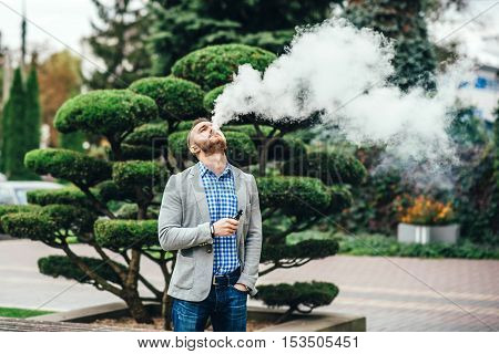 Men With Beard Smoking Electronic Cigarette Outdoor