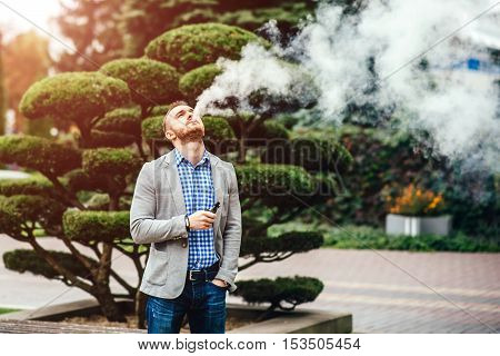 Men With Beard Smoking Electronic Cigarette Outdoor