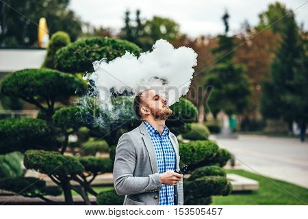 Men With Beard Smoking Electronic Cigarette Outdoor