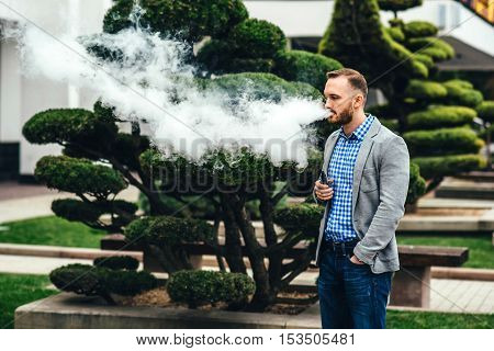 Men With Beard Smoking Electronic Cigarette Outdoor