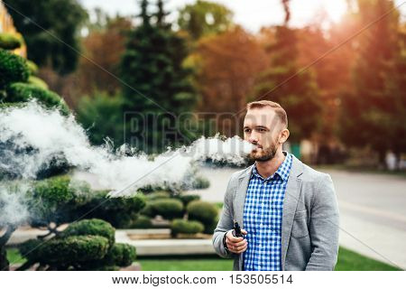 Men With Beard Smoking Electronic Cigarette Outdoor