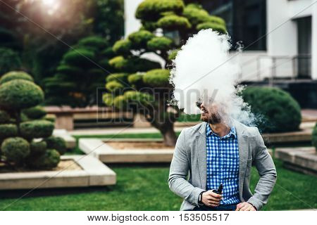 Men With Beard Smoking Electronic Cigarette Outdoor
