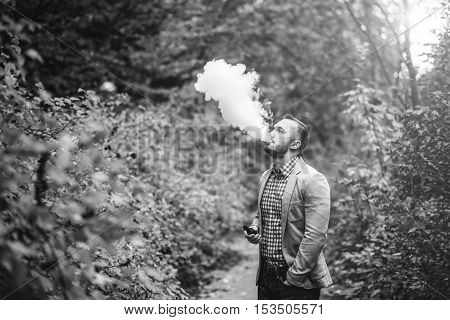 Men With Beard Smoking Electronic Cigarette Outdoor