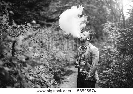 Men With Beard Smoking Electronic Cigarette Outdoor