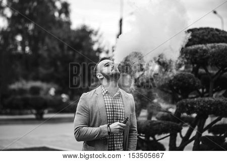 Men With Beard Smoking Electronic Cigarette Outdoor