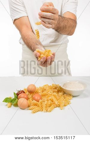 Cook in white coats preparing the sauce for Italian pasta.