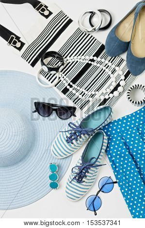 Fashion accessories in black and white and blue colors - hat clothing shoes and bag bracelets and glasses.