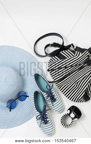 Fashion accessories in black and white and blue colors - hat clothing shoes and bag bracelets and glasses.