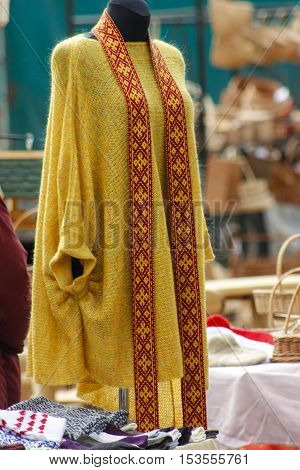 Latvian traditional folk belt and knitted cardigan on a manikin.