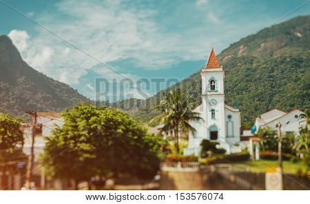 Exterior of brazilian small church with a bell tower in a sunny and hot day