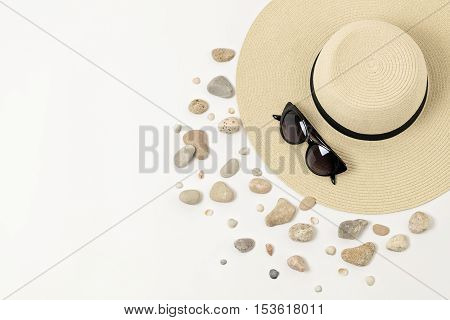 Fashion accessories - hat sunglasses and bracelets. Marine concept sea shells and sea pebbles.