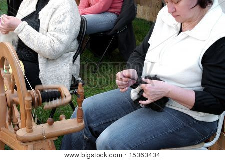 RATIBORICE, Tsjechië - 24 APRIL: oudere vrouw spinnen van wol op traditionele spinnewiel - Th