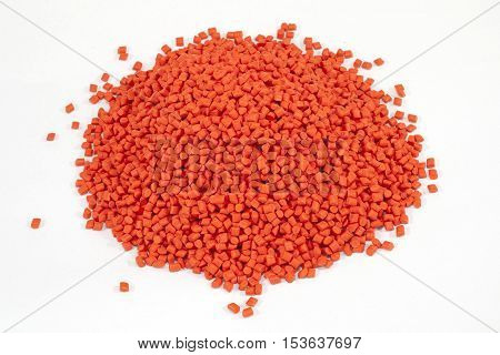 orange plastic polymer granules on white background