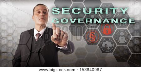 Confident male business manager is touching SECURITY GOVERNANCE onscreen. Information technology metaphor and business concept for the enforcement of an enterprise computer security policy.