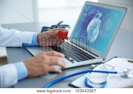 Cardiologist working with laptop at office. Health care concept.