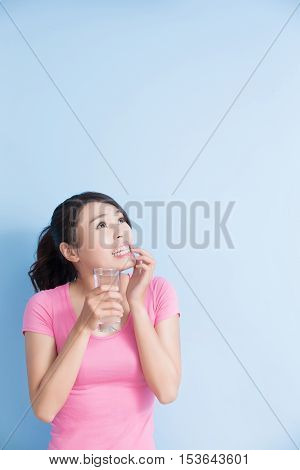 woman drink water with sensitive teeth isolated on bluebackground