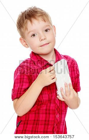 Cute little boy in a red shirt holds his box of watercolors.Isolated on white background