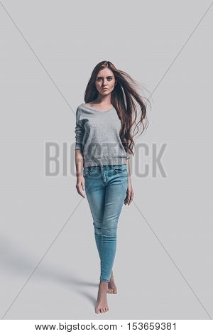 Confident and beautiful. Full length studio shot of attractive young woman in casual wear walking and looking at you
