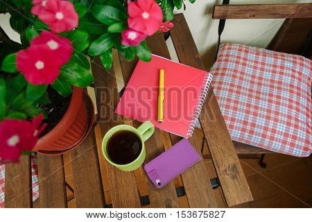 home office on the terrace, close-up, table, notebook, coffee mug