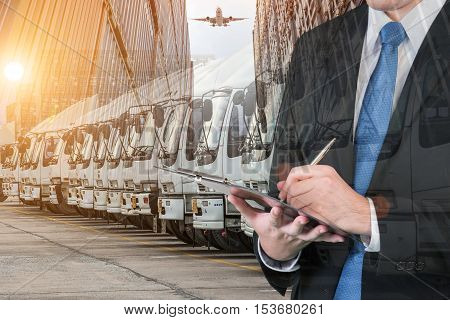 Double exposure of businessman is booking with blurred cargo transportation port and world map. Transportation logistic business concept.