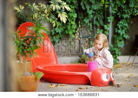 Little Girl Playing In A Sandbox