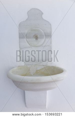 antique stoup placed on a white wall