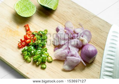 Red Onion Chopped, Chilli Chopped  And Lemon On Wooden Chopping Board
