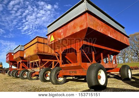 Row of colorful gravity boxes for self unloading of small grain.