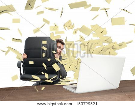 Scared businessman hidden behind the chair submerged by the mail