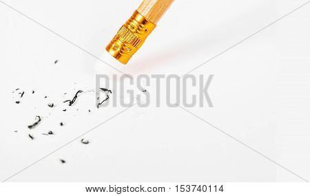 Pencil eraser removing a written mistake on a white paper mistake concept.