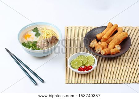 Rice porridge with mined pork and chicken lever served with side dish as Patongko (deep-fried dough stick) and spicy sour filling.