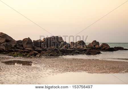 Rugged coastline and tide on the beach at sunrise