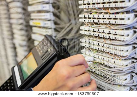 Close-Up of technician using digital cable analyzer in server room