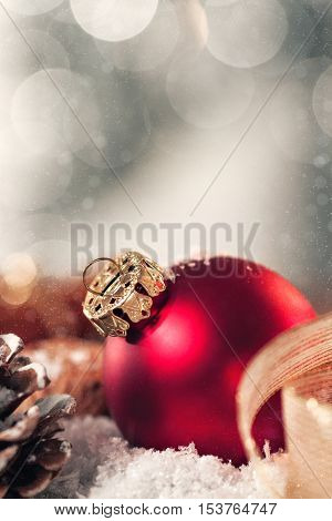 Christmas decoration with candles fir cones nuts snow and ribbon bokeh closeup toned 