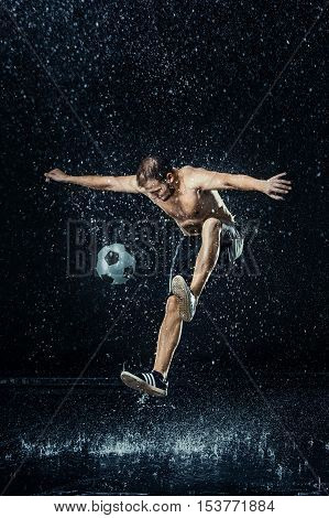 Water drops around football player on black background