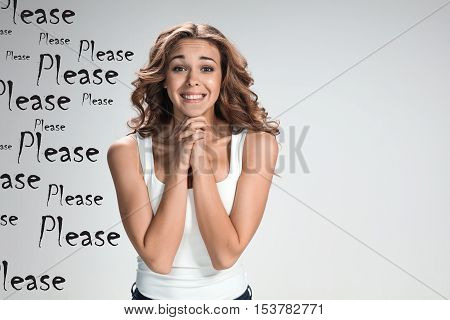 The young appealing womant with happy emotions on gray background with mark PLEASE