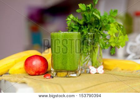 healthy food, organic food and diet concept - fresh green juice with parsley and vegetables on the table
