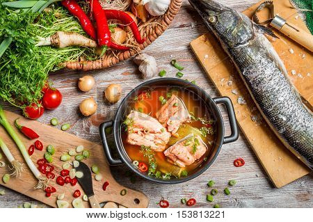 Fresh ingredients for fish soup on old wooden table