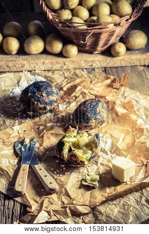 Jacket potatoes with salt and butter on old wooden table