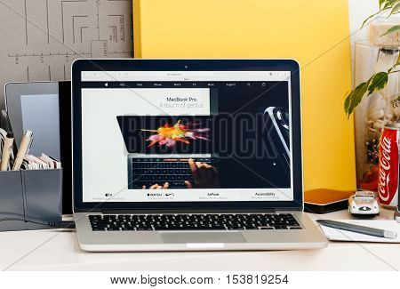 PARIS FRANCE - OCT 28 2016: Apple Computers website on new MacBook Pro Retina with OLED touch bar in a geek creative room showcasing new professional laptop - detail of laptop and iphone 7