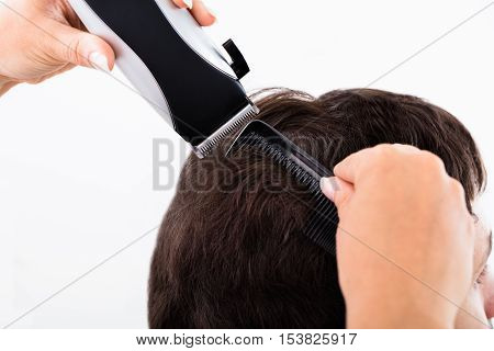 Close-up Of A Hairdresser Cutting Man's Hair With Electric Trimmer At Salon