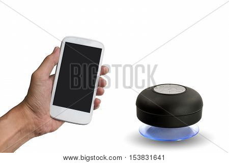 Hand holding smart phone with bluetooth speaker isolated on white background.