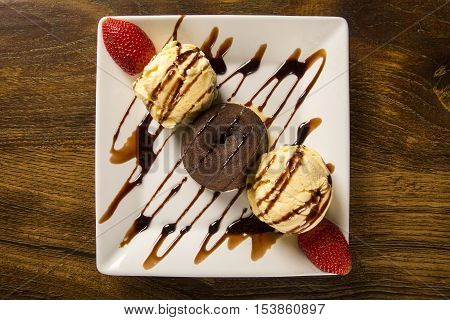 Petit Gateau Dessert With Ice Cream And Strawberry On Wooden Background