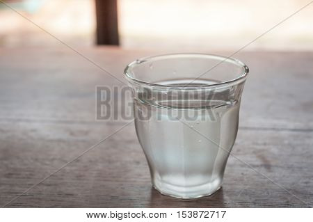 Drinking water in a glass on wooden table, stock photo