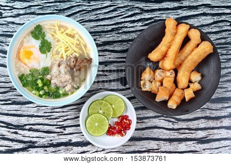 Rice porridge with mined pork and chicken lever served with side dish as Patongko (deep-fried dough stick) and spicy sour fillin.