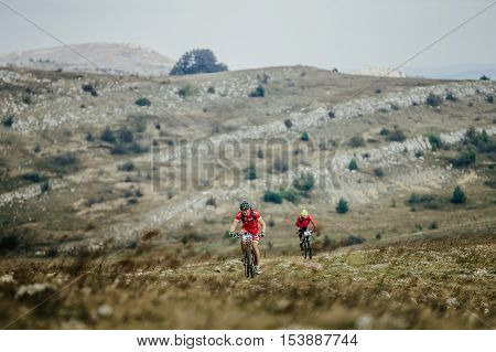 Privetnoye Russia - September 21 2016: two riders rider mountain bike rides on a mountain trail during Crimean race mountainbike